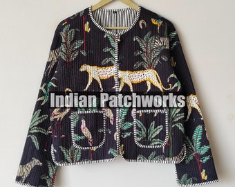 Könnte beinhalten: Eine schwarze Steppjacke mit Dschungel-Print mit Tigern, Vögeln und Blättern. Die Jacke hat einen runden Ausschnitt, zwei Vordertaschen und ein gestreiftes Futter. Die Jacke hängt an einem Holzbügel.