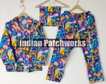 May include: A blue pajama set with a colorful mushroom print, including a button-down shirt, pants, and a matching eye mask. The set is displayed on hangers against a white wall. The pajama set has white trim.