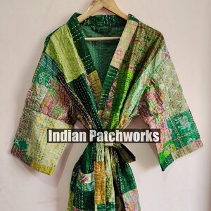 May include: A green and yellow patchwork robe with a tie belt. The robe is made of quilted fabric and has a variety of patterns. The text "Indian Patchworks" is visible on the robe.