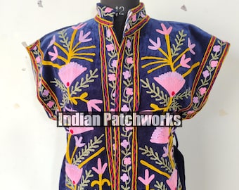 May include: A navy blue embroidered jacket with a high collar and short sleeves. The jacket features pink and yellow floral embroidery with green leaves. The text "INDIAN PATCHWORKS" is visible on the front.