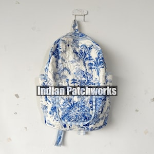 May include: A white and blue quilted backpack with a toile pattern featuring tigers and foliage. The backpack has a top handle, two side pockets, and adjustable straps. The text "Indian Patchworks" is across the front.