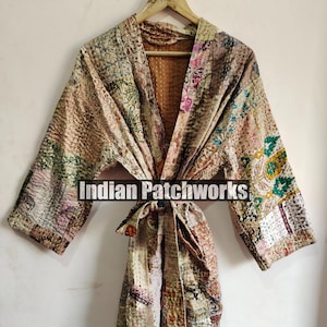 Może przedstawiać: Szlafrok kimono w patchworku w kolorze beżowym, brązowym i różowym z paskiem do wiązania. Szlafrok ma wzór kwiatowy i geometryczny. Na szlafroku widoczny jest napis "Indian Patchworks".