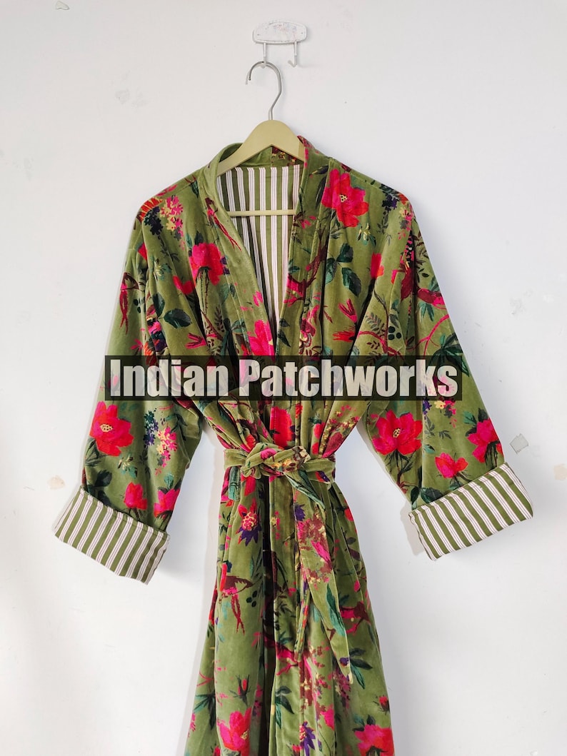 Puede incluir: Bata verde con estampado floral, flores rojas y cintur&oacute;n a juego. La bata tiene pu&ntilde;os a rayas y un interior a rayas. El texto "Indian Patchworks" est&aacute; en la parte delantera de la bata.