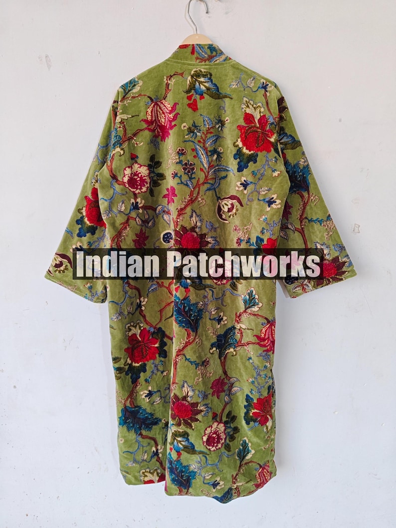 May include: A green velvet robe with a floral print. The robe has a mandarin collar and long sleeves. The text "Indian Patchworks" is visible on the robe.