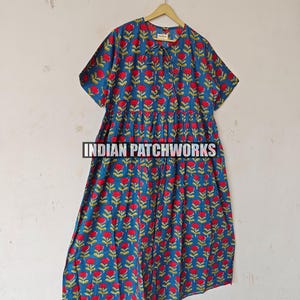 May include: A blue dress featuring a red floral design. The dress has short sleeves and a gathered waist. The text "INDIAN PATCHWORKS" is visible at the bottom of the image.