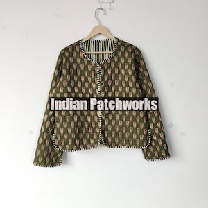 May include: A quilted jacket with a green background and a repeating pattern of red and white shapes. The jacket has a round collar and is lined with a striped fabric. The text "Indian Patchworks" is across the bottom.