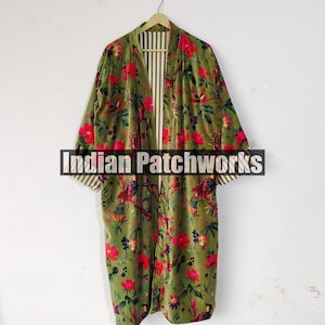 Puede incluir: Una bata larga de color verde oliva con un estampado floral de flores rojas y p&aacute;jaros. La bata tiene un interior a rayas y est&aacute; colgada de una percha de madera. El texto "Indian Patchworks" est&aacute; en la parte inferior.