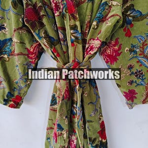 May include: A green velvet robe with a floral print. The robe has a tie belt and long sleeves. The text "Indian Patchworks" is visible on the robe.