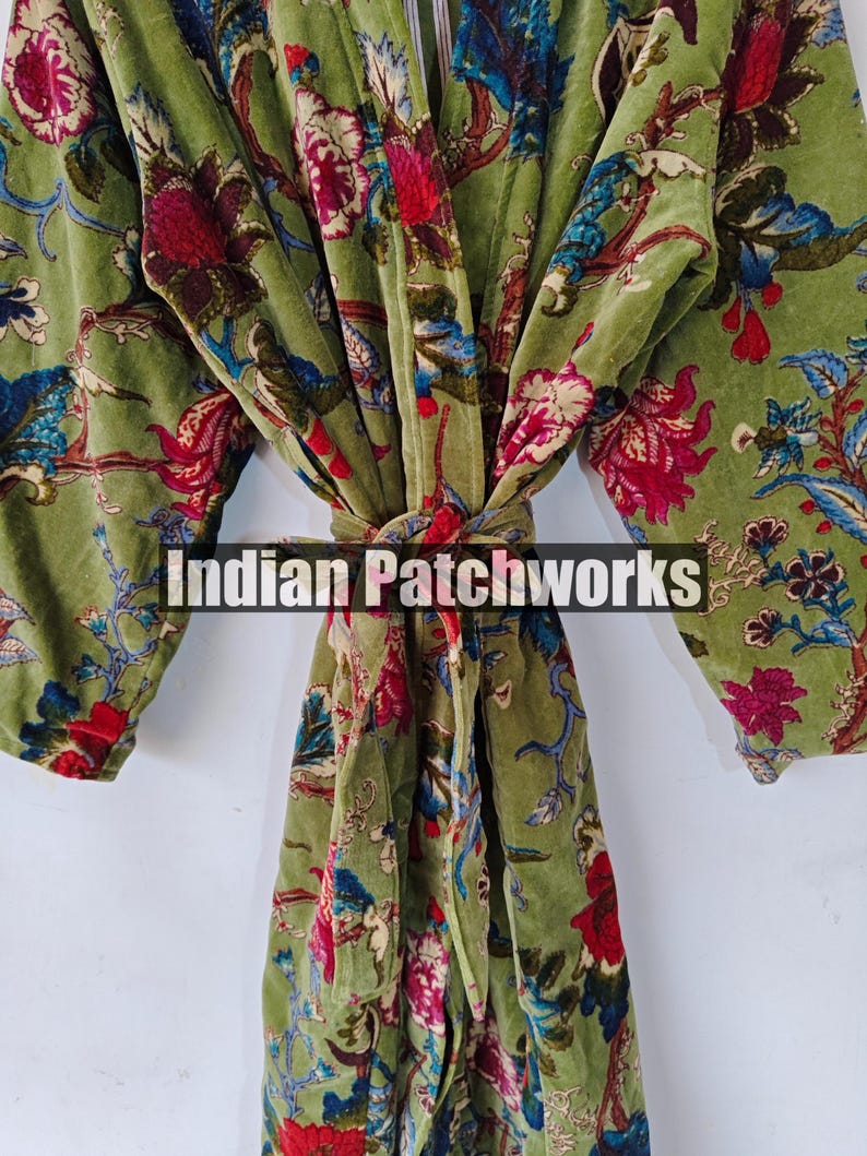 May include: A green velvet robe with a floral print. The robe has a tie belt and long sleeves. The text "Indian Patchworks" is visible on the robe.
