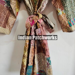 May include: A brown, beige, and pink patchwork robe with a tie belt. The robe is made of quilted fabric and has a variety of patterns. The text "Indian Patchworks" is visible on the robe.