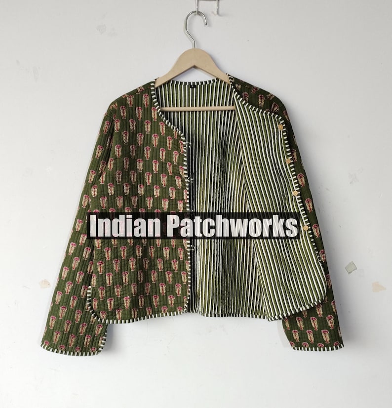 May include: Olive green quilted jacket with a floral pattern on the exterior and a striped interior. The jacket has a round collar and button closure. The text "Indian Patchworks" is visible on the front.