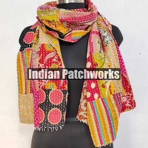 Puede incluir: Una colorida bufanda de patchwork con una variedad de patrones y colores, incluyendo rojo, rosa, amarillo y negro. La bufanda est&aacute; colocada sobre un maniqu&iacute; y presenta el texto "Indian Patchworks".