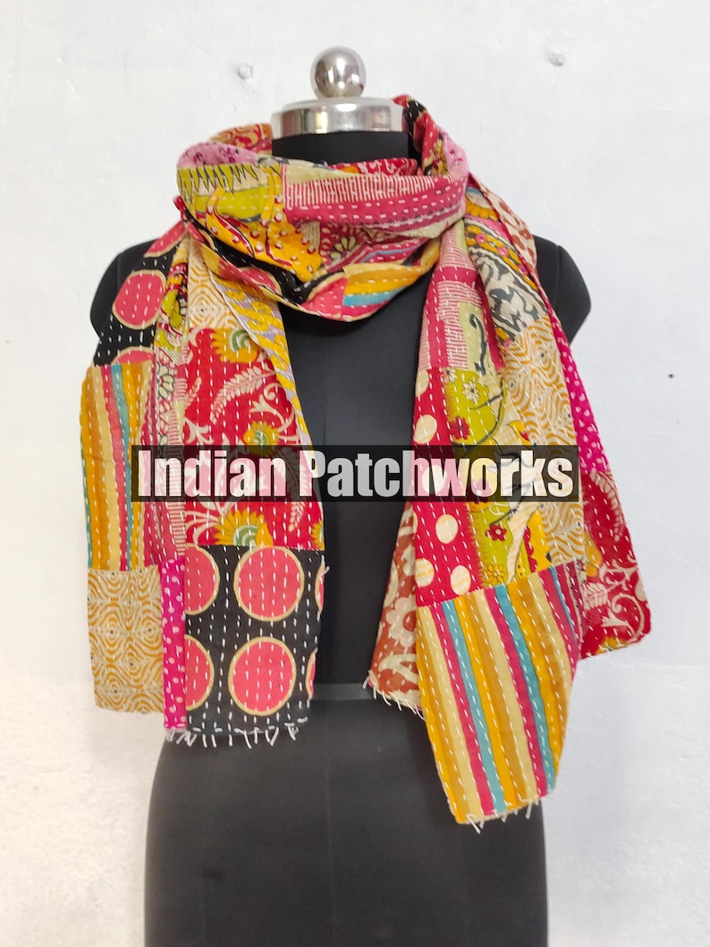 Puede incluir: Una colorida bufanda de patchwork con una variedad de patrones y colores, incluyendo rojo, rosa, amarillo y negro. La bufanda est&aacute; colocada sobre un maniqu&iacute; y presenta el texto "Indian Patchworks".