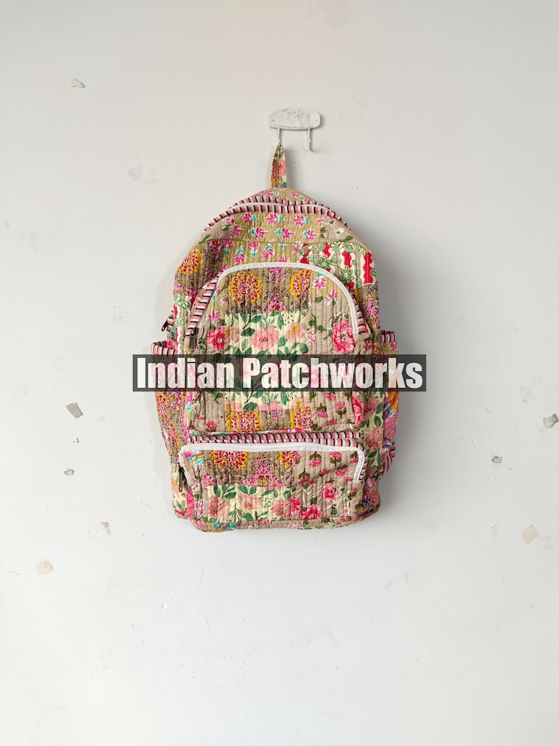 May include: A quilted backpack with a floral pattern in pink, yellow, and green. The backpack has a white zipper and trim, with the text "Indian Patchworks" across the front.