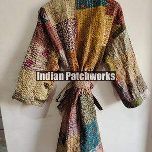 May include: A multi-colored patchwork robe with a tie belt. The robe is made of quilted fabric and has a variety of floral and geometric patterns. The text "Indian Patchworks" is printed on the robe.