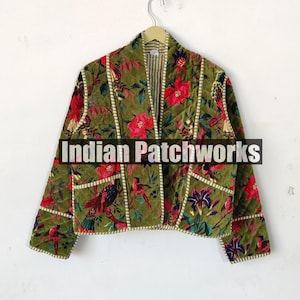 Op de afbeelding: Een groen fluwelen jasje met een bloemen- en vogelprint. Het jasje heeft een mandarijnsluiting en een voorsluiting. De tekst "Indian Patchworks" is op de voorkant van het jasje gedrukt.