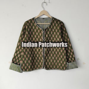 May include: Olive green quilted jacket with a repeating floral pattern in red and white. The jacket features a round collar, button closure, and striped cuffs. The text "Indian Patchworks" is across the front.