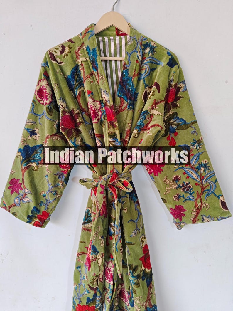 May include: A green velvet robe with a floral print. The robe has a tie belt and a striped lining. The text "Indian Patchworks" is visible on the robe.
