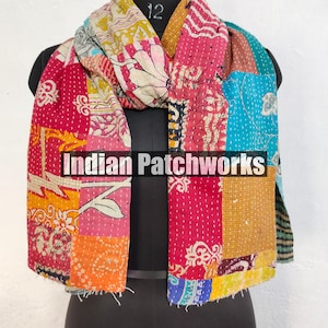 Puede incluir: Bufanda de patchwork colorida con el texto "Indian Patchworks" en la parte delantera. La bufanda presenta una variedad de telas en tonos de rosa, rojo, naranja, amarillo, azul y blanco. La bufanda est&aacute; colocada sobre un maniqu&iacute; negro.