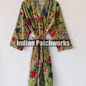 May include: A green velvet robe with a floral print and a matching tie belt. The robe has a white and green striped lining. The text "Indian Patchworks" is visible on the robe.