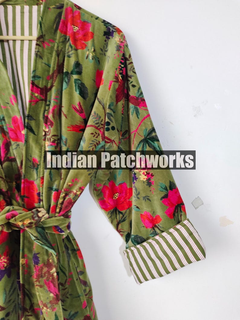 Puede incluir: Bata con estampado floral verde oliva con cintur&oacute;n anudado. La bata presenta un vibrante dise&ntilde;o floral rojo y rosa. Los pu&ntilde;os y el forro interior tienen un estampado de rayas. El texto "Indian Patchworks" es visible en la bata.