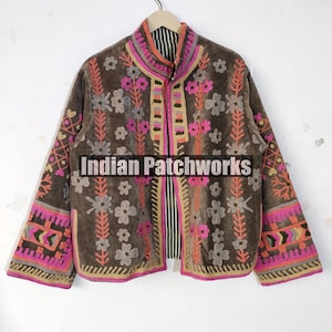 May include: A brown jacket with pink, orange, and grey floral embroidery. The jacket has a stand-up collar and detailed patterns on the sleeves and front. The text "Indian Patchworks" is displayed on the front of the jacket.