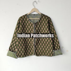May include: Olive green quilted jacket with a repeating floral pattern in red and white. The jacket has a striped lining and trim. The text "Indian Patchworks" is across the front.