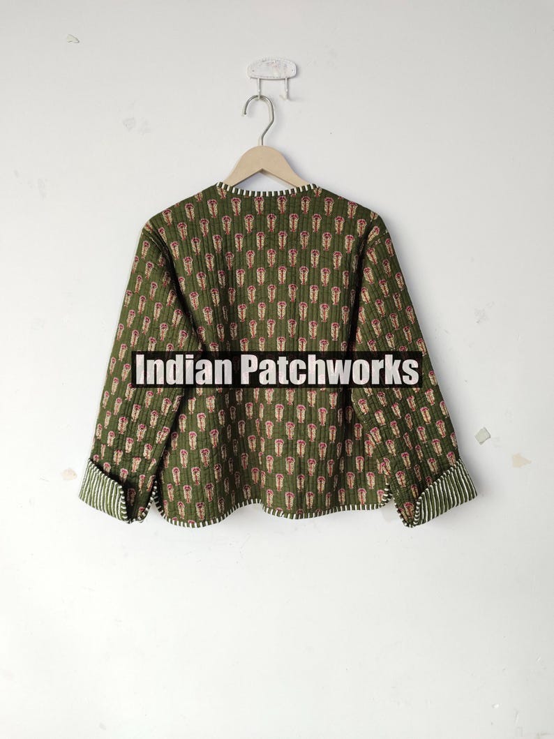May include: A green quilted jacket with a repeating floral pattern in red and white. The jacket has long sleeves with striped cuffs and the text "Indian Patchworks" across the front.
