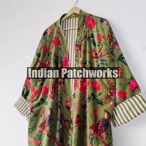 Puede incluir: Un kimono de terciopelo verde con un estampado floral y de p&aacute;jaros en rojo, rosa y amarillo. Las mangas tienen un dobladillo con tela a rayas. El texto "Indian Patchworks" est&aacute; presente.