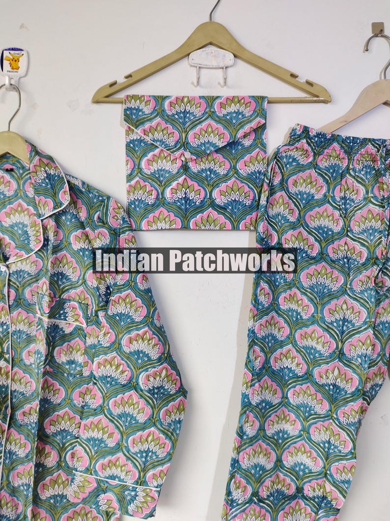 May include: A pajama set with a floral pattern in teal, pink, and white. The set includes a button-down shirt, pants, and a matching pouch. The text "Indian Patchworks" is visible.