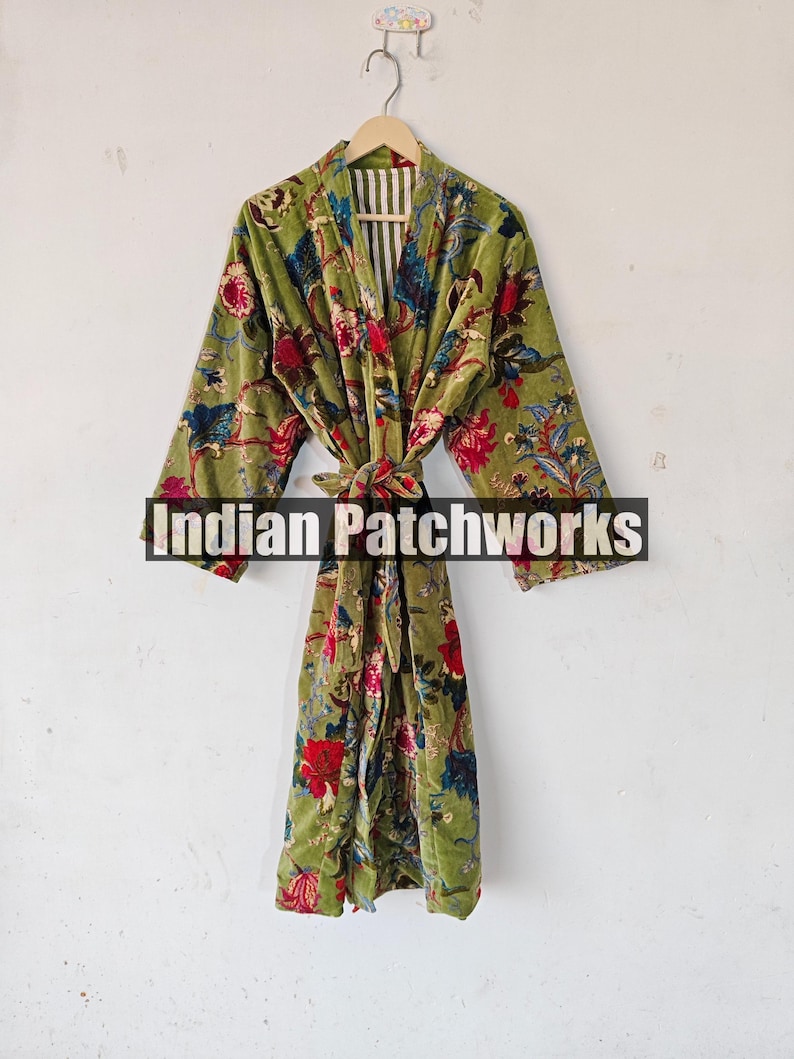May include: A green velvet robe with a floral print. The robe has a tie belt and a white and green striped lining. The text "Indian Patchworks" is visible on the robe.