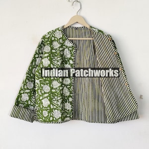 May include: A green quilted jacket with a floral print on one side and a striped pattern on the other side. The jacket has a button closure and a collar.