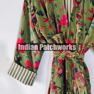 Puede incluir: Una bata de terciopelo verde con un estampado floral en rosa, rojo y morado. La bata tiene un cintur&oacute;n a juego y pu&ntilde;os a rayas. El texto "Indian Patchworks" est&aacute; en la parte delantera.