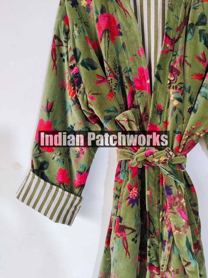 Puede incluir: Una bata de terciopelo verde con un estampado floral en rosa, rojo y morado. La bata tiene un cintur&oacute;n a juego y pu&ntilde;os a rayas. El texto "Indian Patchworks" est&aacute; en la parte delantera.