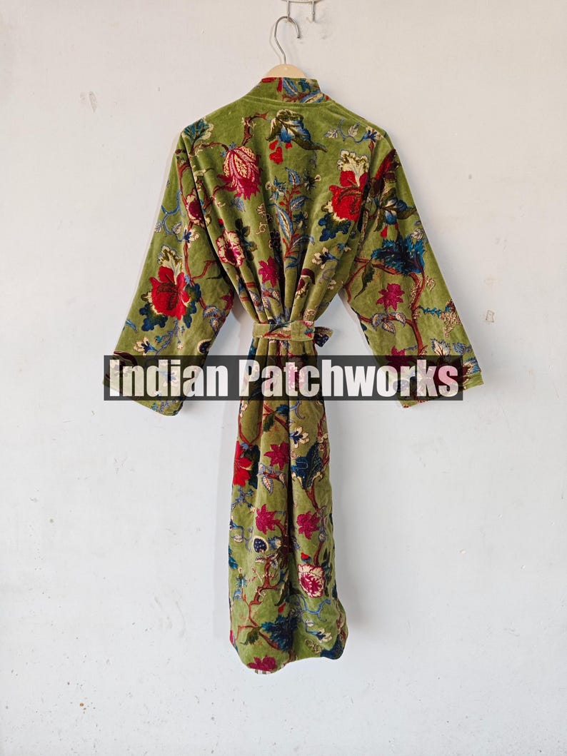 May include: A green velvet robe with a floral print. The robe has a tie belt and long sleeves.