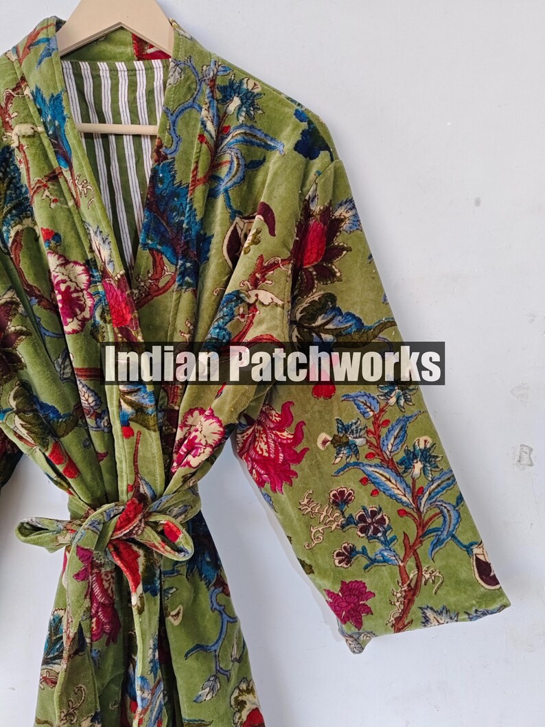 May include: A green velvet robe with a floral print and a red sash. The robe has a white and green striped lining. The text "Indian Patchworks" is visible on the robe.