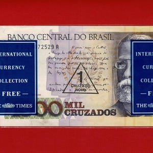 May include: A Brazilian 1000 Mil Cruzados banknote from the International Currency Collection, featuring a portrait of a man with glasses. The banknote is in a clear plastic sleeve and has blue labels with text.