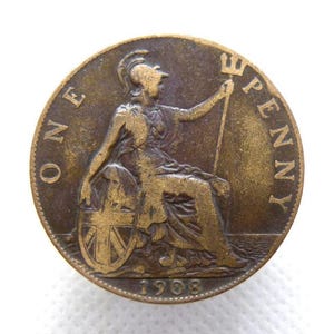May include: A bronze 1908 British penny coin. The coin depicts Britannia, seated and holding a trident, with a shield bearing the Union Jack. The words "ONE PENNY" are inscribed around the coin's edge.