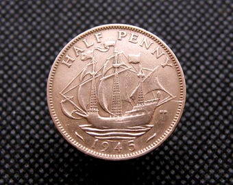 May include: A copper-colored British half penny coin with the inscription "HALF PENNY" and the year "1945". The coin features a ship with sails.