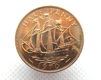 May include: A copper-colored British half penny coin with the year 1970 and the words "HALF PENNY" around the edge. The coin features a ship with sails and the words "HMS" on the bottom.