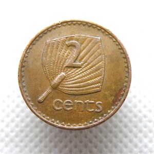 Könnte beinhalten: Bronzefarbene Münze mit Fächerdesign und der Zahl "2" in der Mitte. Das Wort "cents" ist darunter aufgedruckt. Die Münze hat einen strukturierten Rand. Der Hintergrund ist weiß. Sammlerstück.