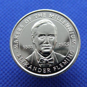 May include: Silver coin commemorating Alexander Fleming, a "Maker of the Millennium". The coin features a portrait of Fleming and the years 1881 and 1955.