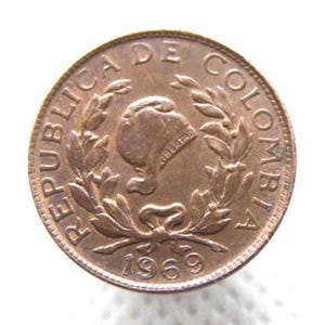 May include: A copper-colored coin from Colombia, dated 1969. The coin features the words "REPUBLICA DE COLOMBIA" around the edge. The center design includes a profile of a woman's head, a laurel wreath, and the word "LIBERTAD".