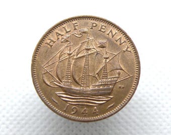 May include: A copper-colored Half Penny coin from 1944, featuring a sailing ship design. The coin's rim is textured, and the words "HALF PENNY" are inscribed at the top. The year "1944" is at the bottom.