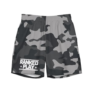 Puede incluir: Shorts deportivos de camuflaje gris y negro con un logotipo blanco que dice "RANKED PLAY" con una estrella a cada lado de la palabra "PLAY".