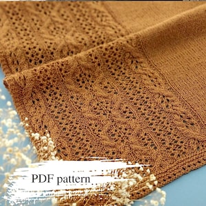 Puede incluir: Primer plano de una bufanda marrón tejida con un delicado calado. La bufanda está doblada, revelando intrincados detalles y texturas. El texto "PDF pattern" es visible en la parte inferior, lo que sugiere un diseño descargable.