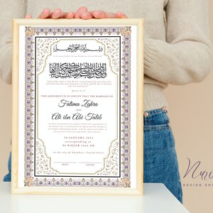 May include: A framed Islamic marriage certificate with ornate gold and white calligraphy. The text includes the names Fatima Zahra and Ali ibn Abi Talib, the date 28 January 2023, and the phrase "This agreement is to certify that the marriage of..."