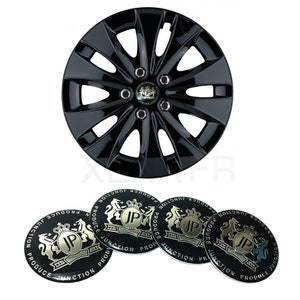 Op de afbeelding: Vier zwarte wieldoppen met een zilveren embleem met de tekst "Junction Produce" en een gouden logo met een kroon en de letters "JP".