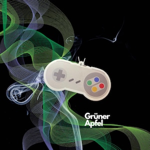 May include: A white and gray video game controller with colorful buttons, surrounded by green and blue smoke. The text "Grüner Apfel" is visible below the controller.