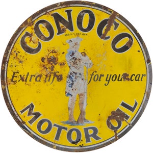 May include: A vintage, round, yellow and black Conoco Motor Oil sign with a faded image of a man in a uniform holding a wrench. The sign reads "Conoco Motor Oil Extra life for your car" and "Reg. U.S. Pat. Off."